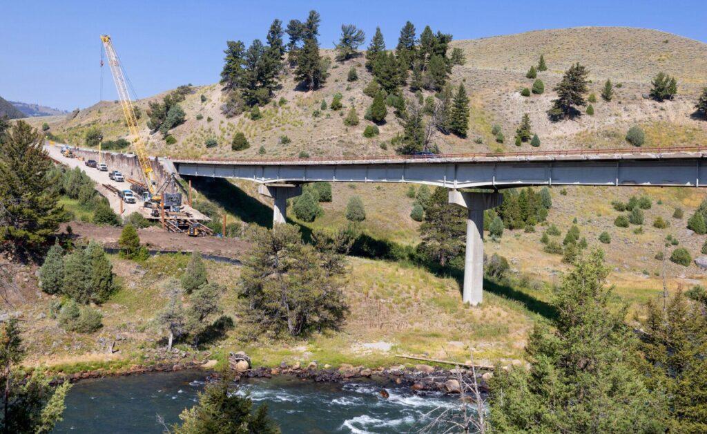 Work to construct a new bridge goes on next to the old one across the Yellowstone River in 2023.